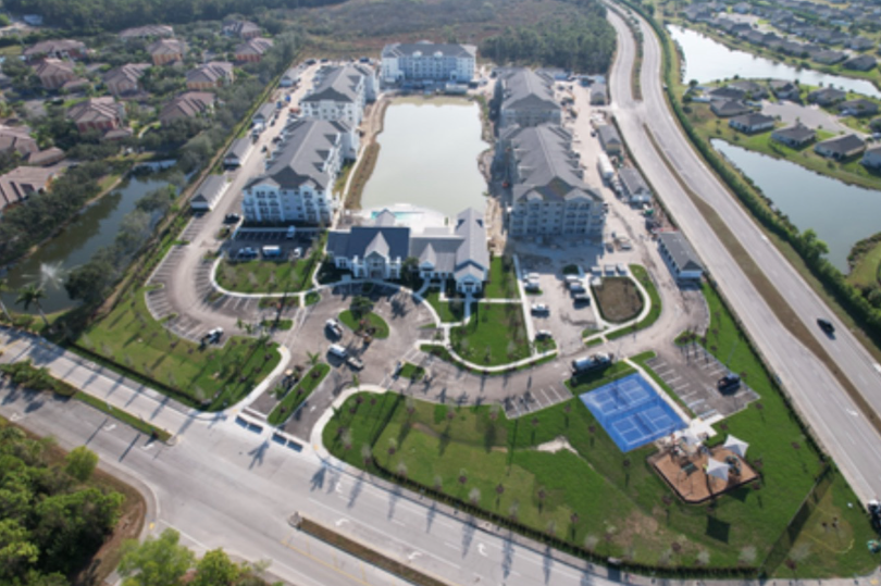 Aerial of the completed Entrada Apartments community with pond and amenities